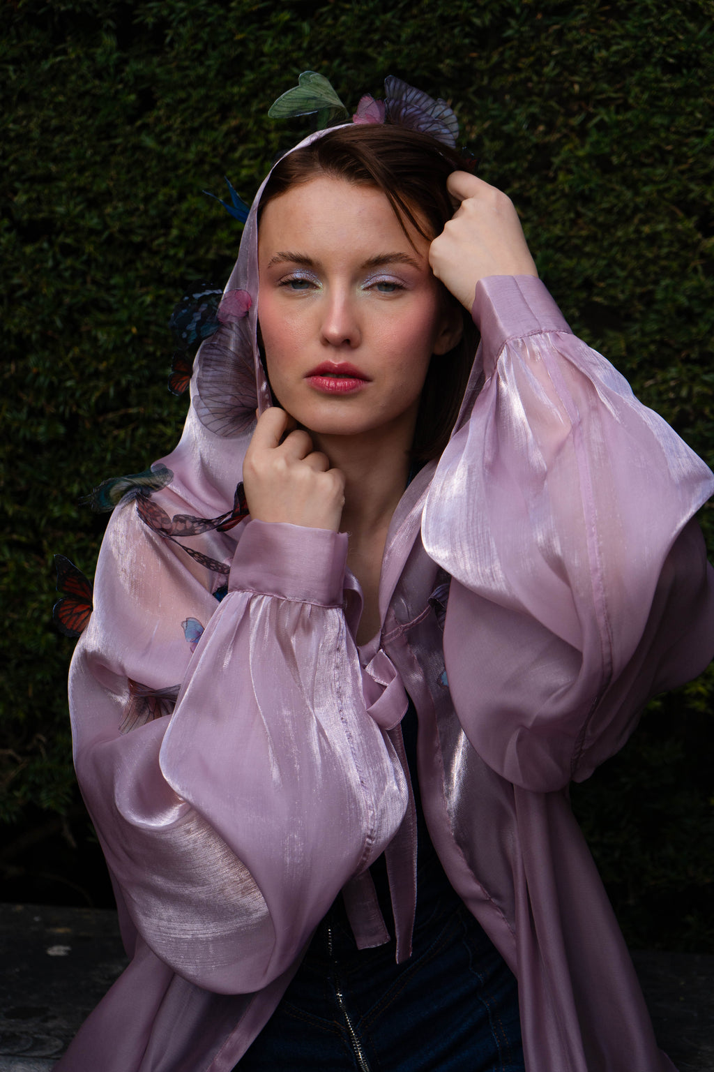 LA CAPE ÉTHÉRÉE — ROSE AUBE

Silhouette vaporeuse &amp; reflets lunaires.

Voile iridescent de haute légèreté captant la lumière pour un effet holographique aux nuances rosées et nacrées.

Papillons découpés et cousus main individuellement, créant un relief organique et poétique sur l'ensemble de la pièce.

Chaque modèle est une pièce unique : le positionnement des papillons étant réalisé à la main, chaque cape possède sa propre constellation de motifs.
