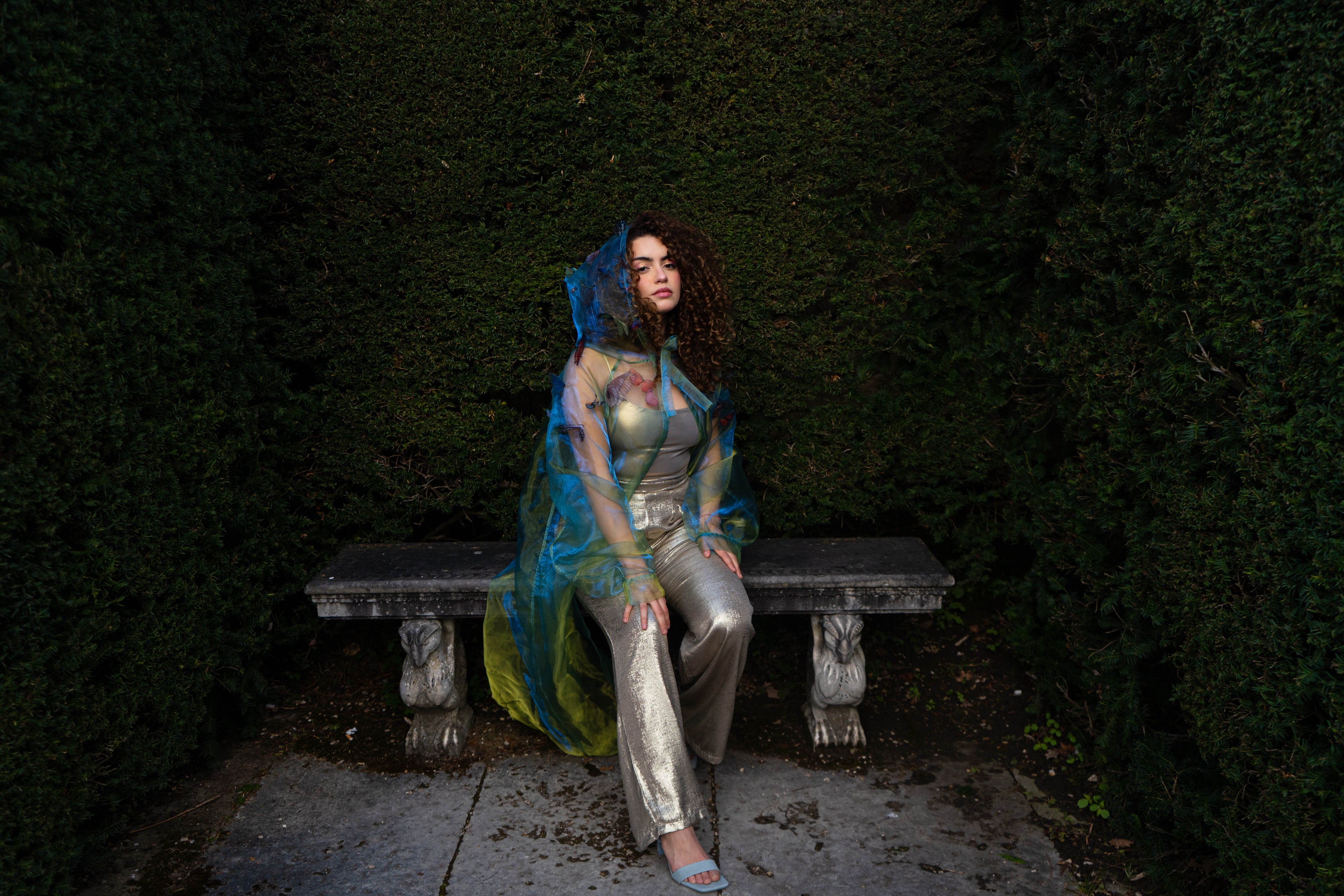 LA CAPE ÉTHÉRÉE — VERT BOREAL

Silhouette vaporeuse &amp; éclats magnétiques.

Voile iridescent de haute légèreté captant la lumière pour un effet holographique aux reflets vert d'eau et dorés.

Papillons découpés et cousus main individuellement, créant un relief organique et poétique sur l'ensemble de la pièce.

Chaque modèle est une pièce unique : le positionnement des papillons étant réalisé à la main, chaque cape possède sa propre constellation de motifs.