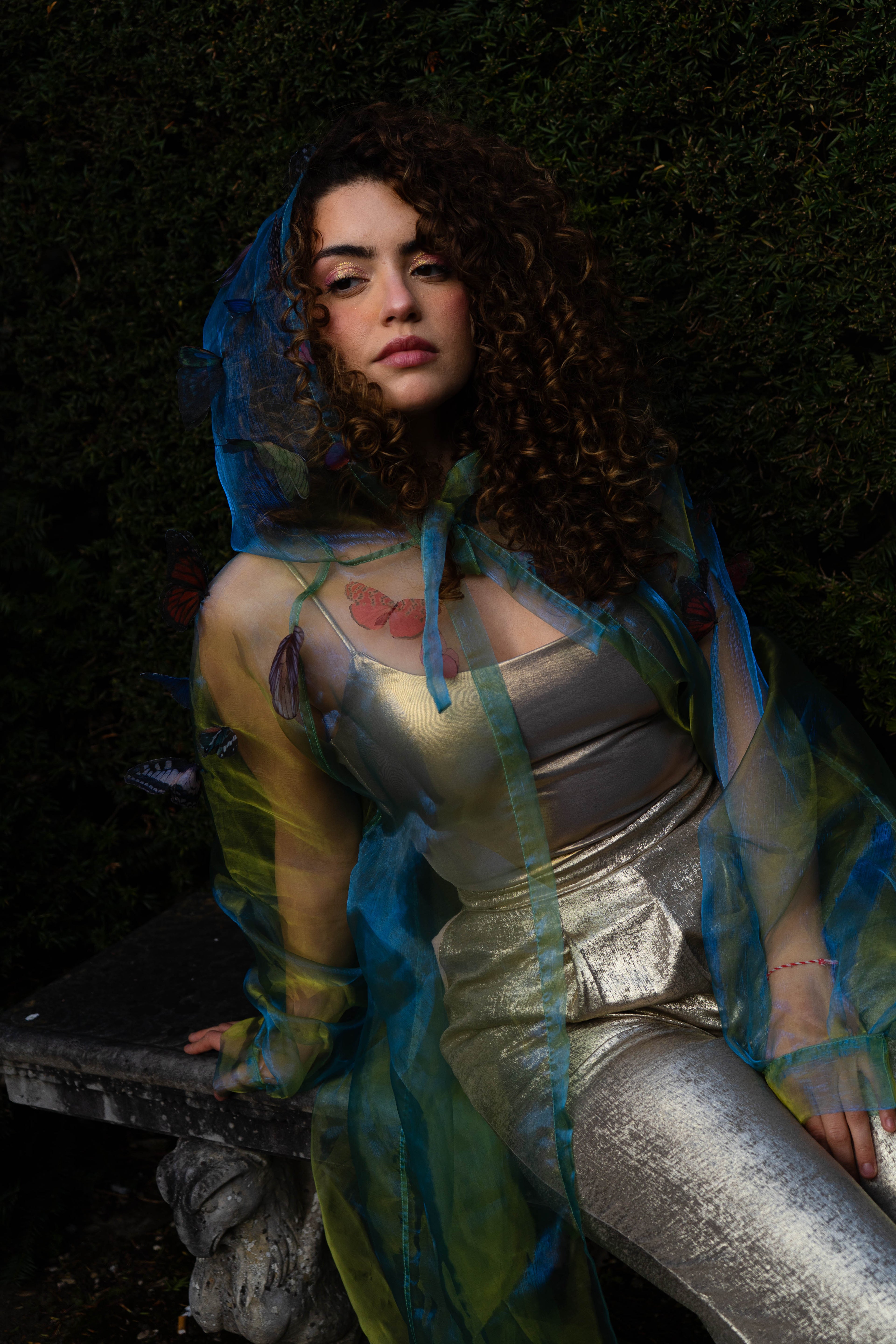 LA CAPE ÉTHÉRÉE — VERT BOREAL

Silhouette vaporeuse &amp; éclats magnétiques.

Voile iridescent de haute légèreté captant la lumière pour un effet holographique aux reflets vert d'eau et dorés.

Papillons découpés et cousus main individuellement, créant un relief organique et poétique sur l'ensemble de la pièce.

Chaque modèle est une pièce unique : le positionnement des papillons étant réalisé à la main, chaque cape possède sa propre constellation de motifs.