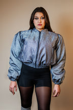 Doudoune réversible - Bleu & argent pailletés. Face bleue matelassée. Face argentée avec finition pailletée. Rembourrée, chaude et confortable. THERMO 150. Manches bouffantes. Fermeture zippée. Poches latérales. Edition limitée à 3 exemplaires.