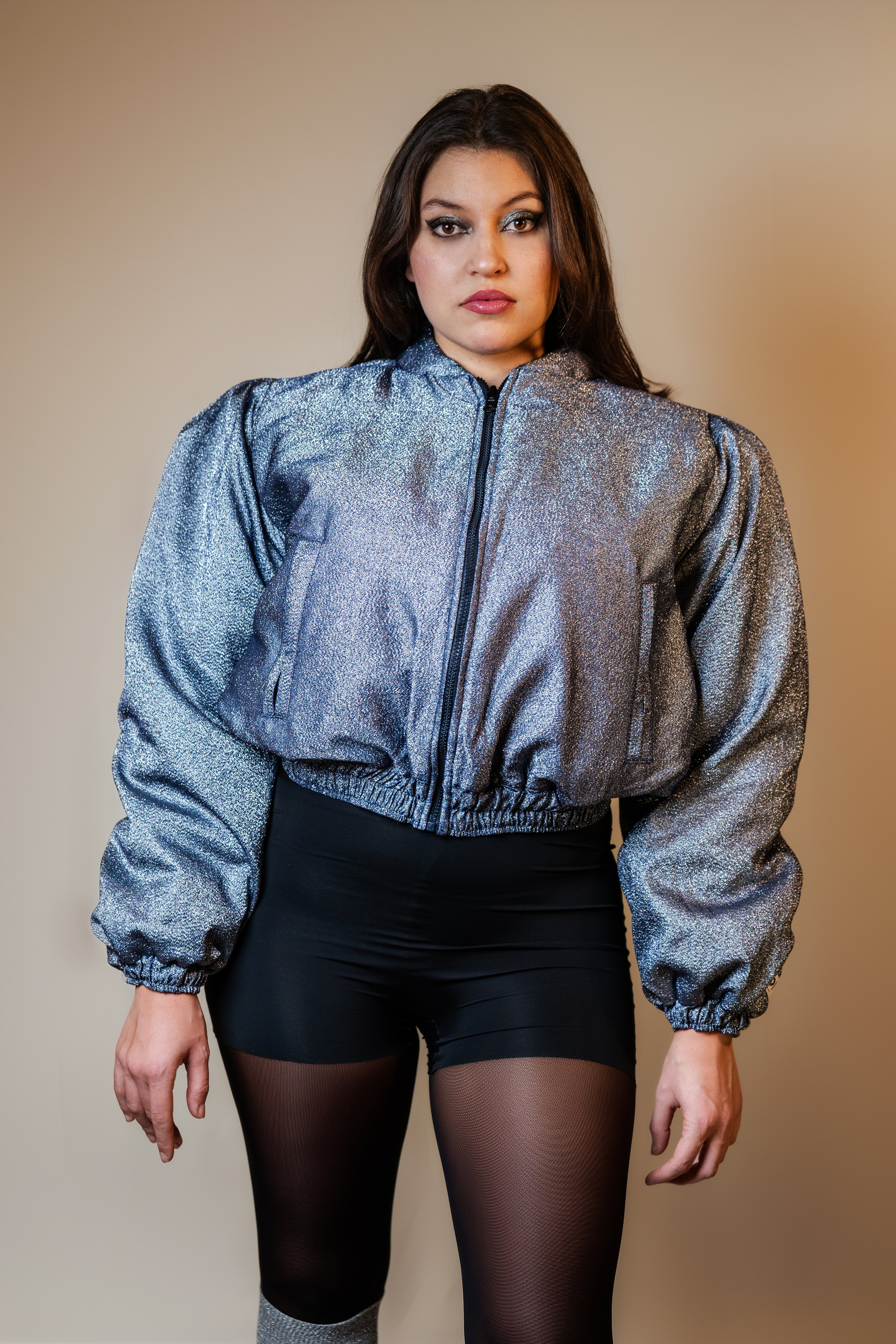 Doudoune réversible - Bleu & argent pailletés. Face bleue matelassée. Face argentée avec finition pailletée. Rembourrée, chaude et confortable. THERMO 150. Manches bouffantes. Fermeture zippée. Poches latérales. Edition limitée à 3 exemplaires.