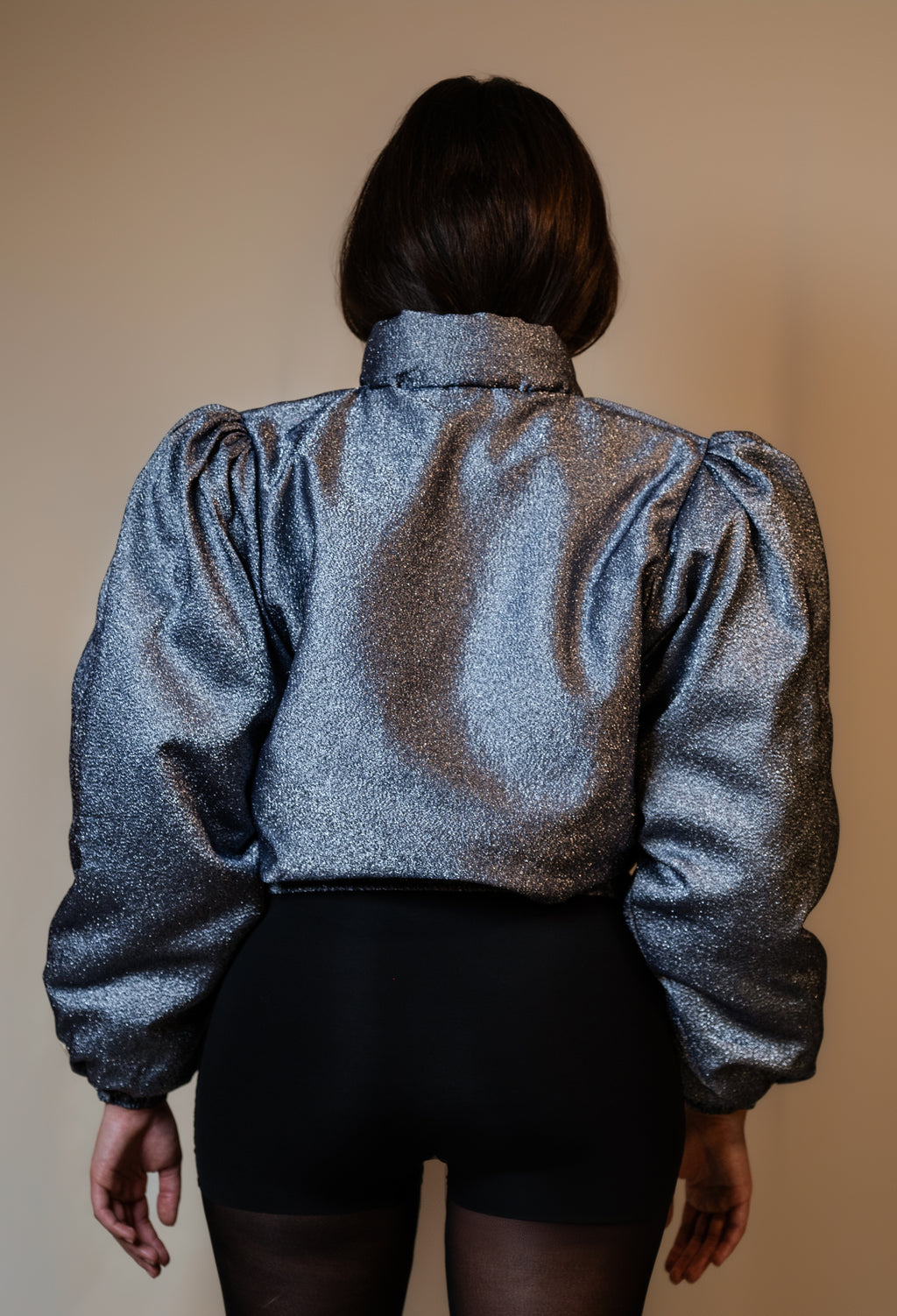 Doudoune réversible - Bleu & argent pailletés. Face bleue matelassée. Face argentée avec finition pailletée. Rembourrée, chaude et confortable. THERMO 150. Manches bouffantes. Fermeture zippée. Poches latérales. Edition limitée à 3 exemplaires.