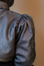 Doudoune réversible - Bleu & argent pailletés. Face bleue matelassée. Face argentée avec finition pailletée. Rembourrée, chaude et confortable. THERMO 150. Manches bouffantes. Fermeture zippée. Poches latérales. Edition limitée à 3 exemplaires.