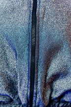 Doudoune réversible - Bleu & argent pailletés. Face bleue matelassée. Face argentée avec finition pailletée. Rembourrée, chaude et confortable. THERMO 150. Manches bouffantes. Fermeture zippée. Poches latérales. Edition limitée à 3 exemplaires.