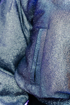 Doudoune réversible - Bleu & argent pailletés. Face bleue matelassée. Face argentée avec finition pailletée. Rembourrée, chaude et confortable. THERMO 150. Manches bouffantes. Fermeture zippée. Poches latérales. Edition limitée à 3 exemplaires.