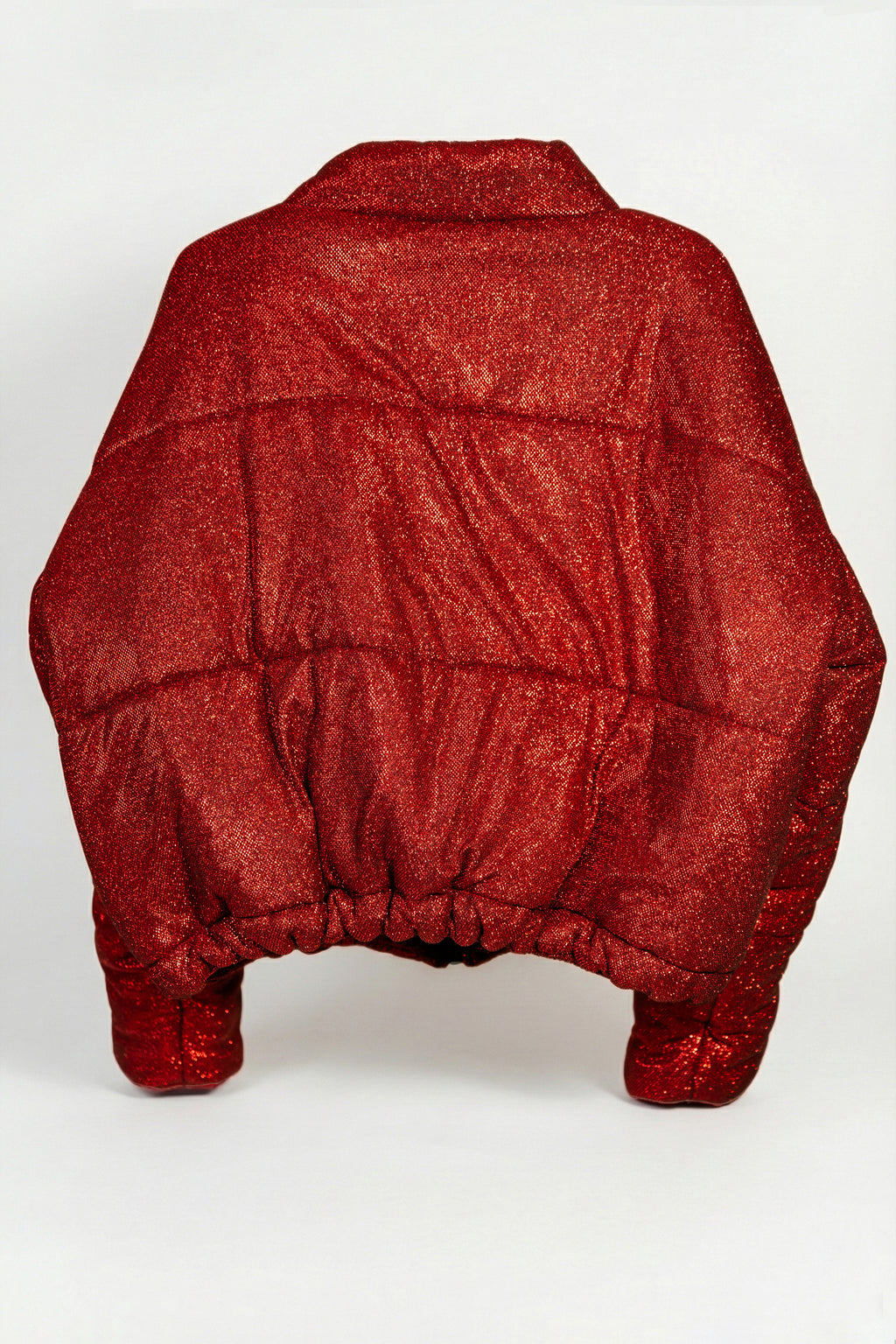 Doudoune - Rouge profond pailletée. Oversize, matelassée et rembourrée. Doublure en satin bleu. THERMO 180. Fermeture zippée et poches latérales zippées. Edition limitée à 3 exemplaires