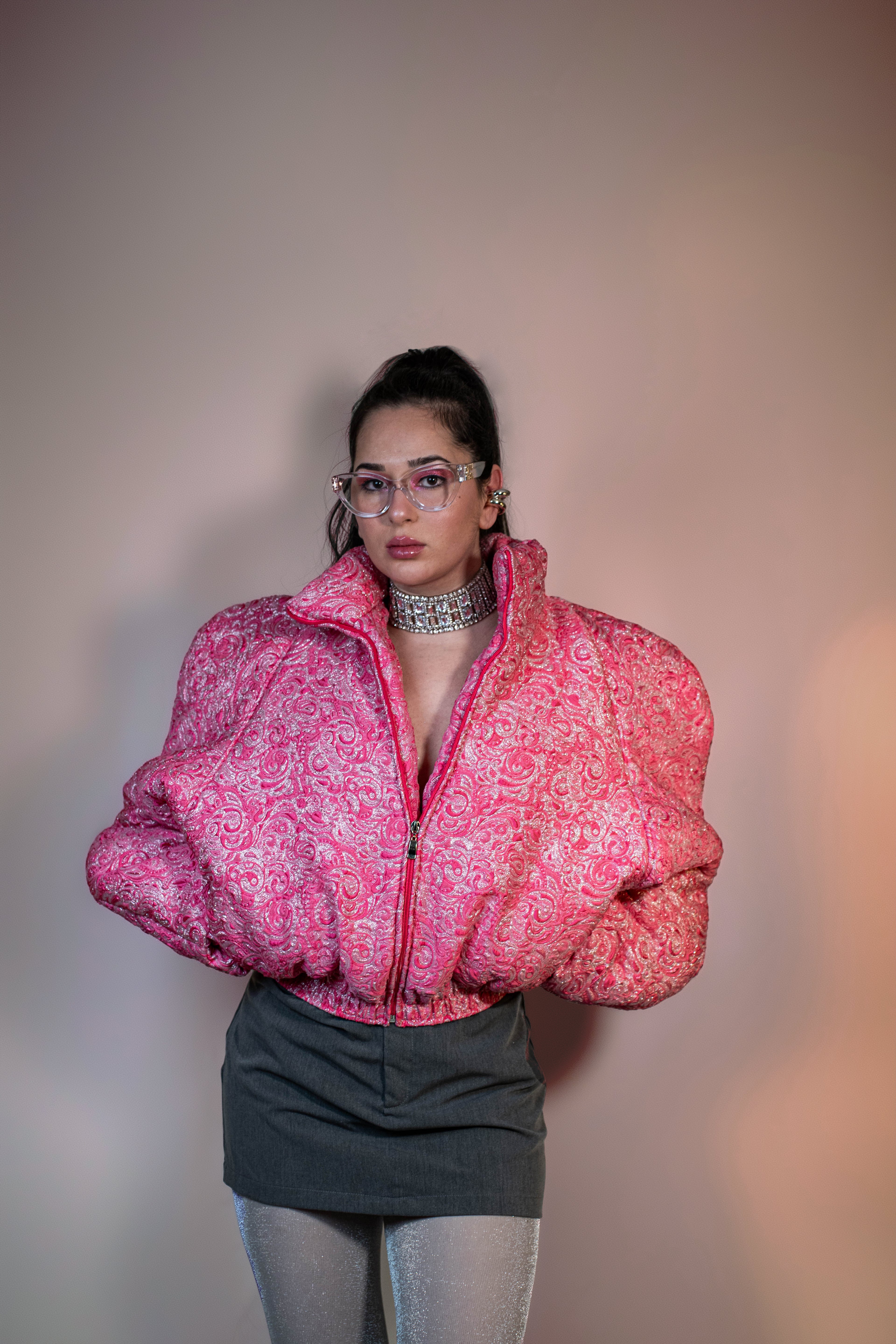 Doudoune rose texturée à effet serti argenté. Manches butterfly structurées. Rembourrage THERMO 180. Doublure satinée grise. Fermeture zippée, poches latérales. Edition limitée à 3 exemplaires