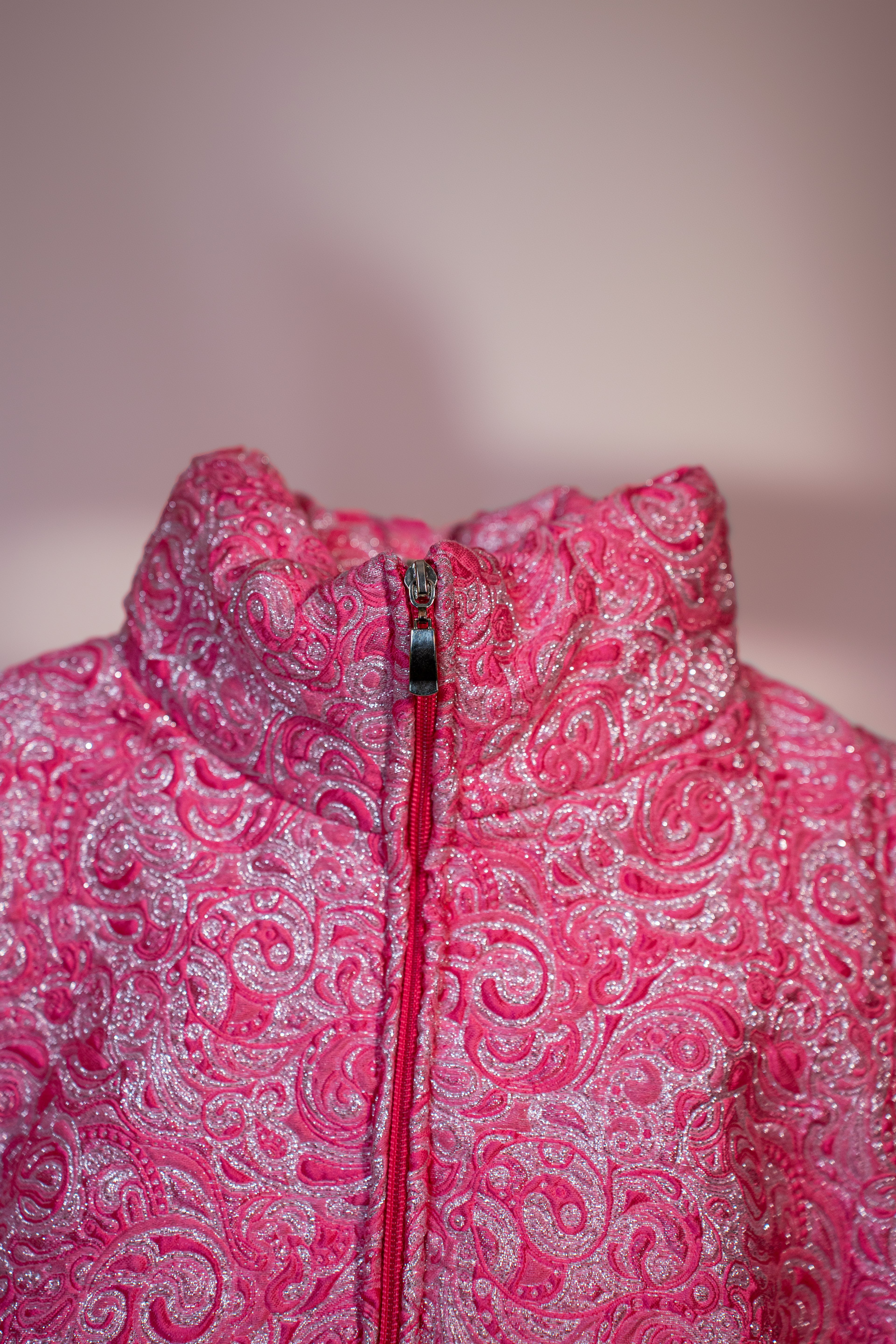 Doudoune rose texturée à effet serti argenté. Manches butterfly structurées. Rembourrage THERMO 180. Doublure satinée grise. Fermeture zippée, poches latérales. Edition limitée à 3 exemplaires